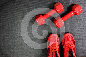 Pair of red sport sneakers and dumbbells, fitness concept