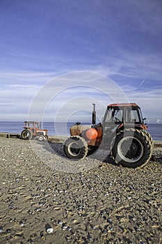 Pair of red tractors on the beach