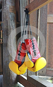 Pair of red-yellow boxing gloves Hanging on wooden