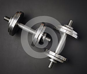 pair of shiny steel typesetting dumbbells for bodybuilding on a black background photo