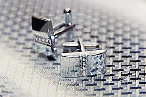 Pair of silver cuff links on the man's tie