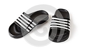 Pair of slide sandals isolated on white. Black rubber slippers closeup. Light shoes for pool or shower. Comfortable beach flip