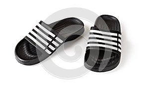 Pair of slide sandals isolated on white. Black rubber slippers closeup. Light shoes for pool or shower. Comfortable beach flip photo