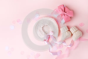 Pair of small baby socks, bonnet, gift box on pink background with copy space for your warm message, baby shower, first newborn