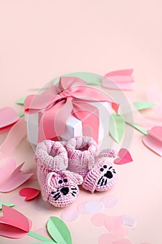 Pair of small baby socks and gift box on pink background with copy space for your warm message, baby shower, first newborn party