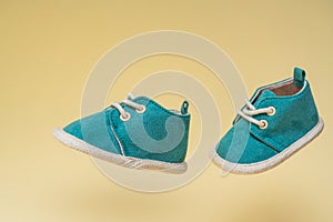 A pair of small children's shoes hovering at different angles. The concept of different twins