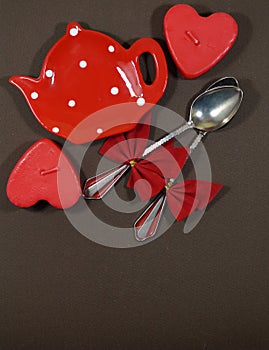 A pair of spoons with red ribbon and two hearts and red plate , Valentine's Day