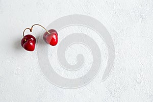 Pair of strange, ugly cherries in the heart shape on a white background. Trendy ugly organic product. Malformed berry