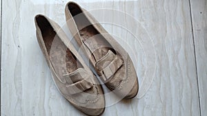 a pair of suede women shoe in cream color which is very dusty and dirty, top view photo angle