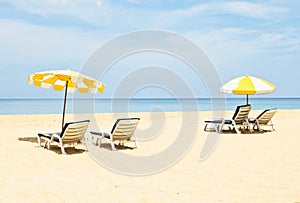 Pair of sun loungers and a beach umbrellas on the beach photo