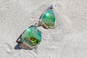 Pair Of Sunglasses On The Beach With A Reflection Of A Beautiful