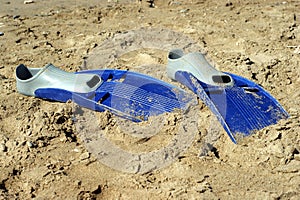 Pair of swimfins on the sand at sea