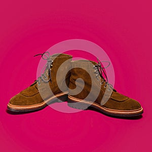 Pair of Tan Brown Suede Split Toe High Boots Closeup With Rude Rubber Sole Placed Together On Red Background