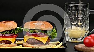 Pair of tasty beef burgers and a mug with beer