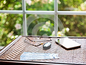 Pair of theater tickets on table with window