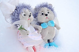 a pair of toy hedgehogs in wedding clothes on a white background,a holiday concept