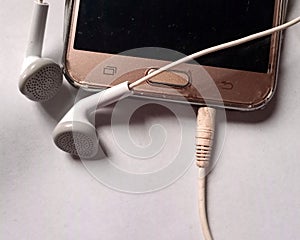 A pair of two earphones connected to a mobile device