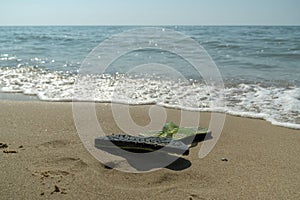 Pair, two of men`s beach slippers on the sand