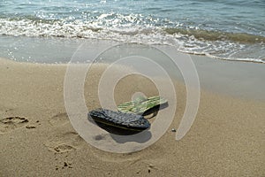 Pair, two of men`s beach slippers on the sand