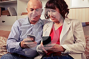 Pair of two merry spouses playing with devices