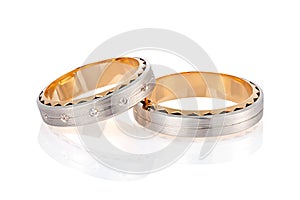 Pair of two tone gold wedding ring with matte surface and diamonds isolated on white background