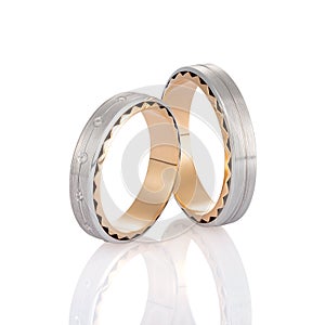 Pair of two tone gold wedding ring with matte surface and diamonds isolated on white background