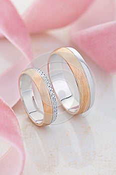 Pair of unique gold wedding rings with diamonds and textured surface