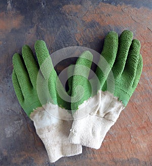 A Pair of Used Garden Work Gloves on a Rustic Slate Background