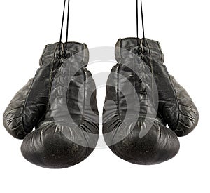 Pair of very old vintage black leather boxing gloves hanging on a rope