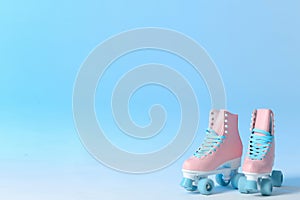 Pair of vintage roller skates on color background