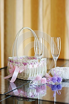 A pair of wedding glasses, basket and a pillow