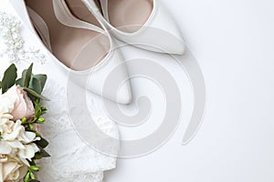 Pair of wedding high heel shoes on white background, top view