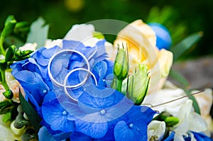 Pair of wedding rings on the background of the bridal bouquet