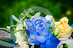 Pair of wedding rings on the background of the bridal bouquet