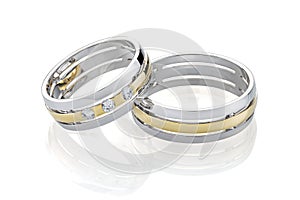 Pair of wedding silver ring and gold rings decorated with diamonds isolated on white background