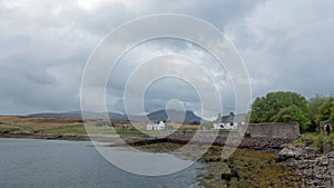 Pair of white cottages on a remote Scottish coastline surrounded