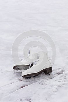 Pair of White Ice Skates in snow