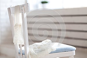 Pair of white nylon stockings hang on back of chair.