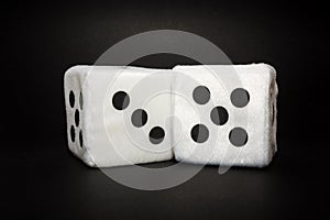 Pair of white plush dices on the black background