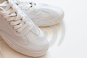 Pair of white sneakers on white background