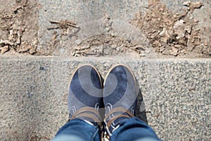 Pair of winter boots on female legs on stairs