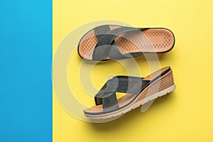 A pair of women`s high-soled sandals on a yellow and blue background. Minimal concept of summer women`s shoes