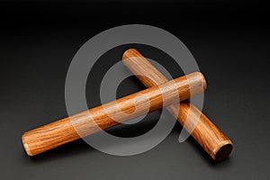 A pair of wooden claves lying on a black underground photo