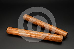 A pair of wooden claves lying on a black underground photo