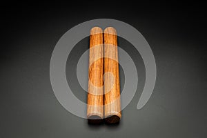 A pair of wooden claves lying on a black underground photo