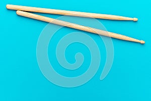 Pair of wooden drumsticks on turquoise blue background