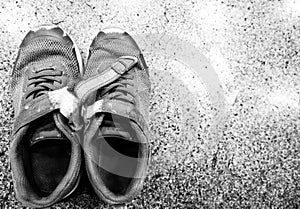 pair of worn out children's sneakers with scuffs damaged straps.