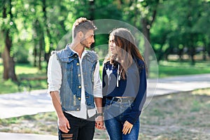 Pair of young people standing in park looking each other