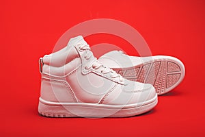 pair of youth sneakers on red background close-up