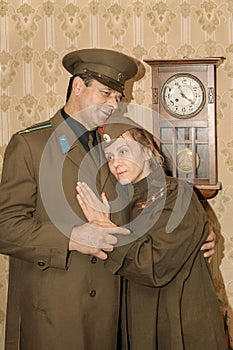 A paired portrait of a military family separated by war. Farewell hugs.